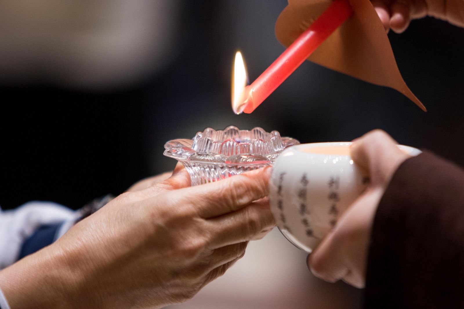 Hands lighting a candle